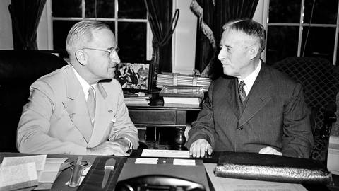 US-Präsident Harry Truman (linkts) nach seiner Rückkehr von der Potsdamer Konferenz an seinem Schreibtisch im Weißen Haus mit Kriegsminister Henry L. Stimson. Die Männer diskutieren über die Atombombe, die auf die japanische Stadt Hiroshima abgeworfen wurde. (Foto: picture-alliance / Reportdienste, picture alliance / ASSOCIATED PRESS)
