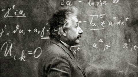 Albert Einstein um 1925. Der Physiker steht vor einer Tafel mit vielen Formeln (Foto: imago images, IMAGO / Cinema Publishers Collection)
