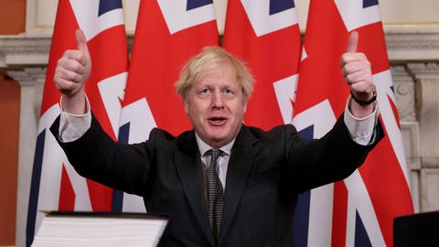 Der britische Premierminister Boris Johnson hält beide Daumen nach oben, nachdem er am 30. Dezember 2020 in Downing Street das Post-Brexit-Handelsabkommen unterzeichnet hat (Foto: imago images, IMAGO / Xinhua)