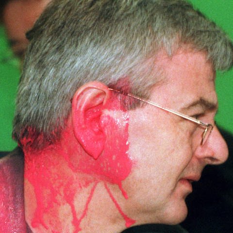 Joschka Fischer (Grüne), kurz nachdem er auf dem Sondersparteitag der Grünen zum Kosovo-Krieg von einem Farbbeutel getroffen wurde. (Foto: dpa Bildfunk, picture alliance/dpa | Bernd Thissen)