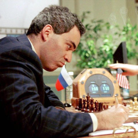 Garri Kasparow aus Russland macht sich am 11. Mai 1997 Notizen. Rechts im Bild Joseph Hoane, der die Züge für den Computer Deep Blue ausführt  (Foto: imago images, IMAGO / UPI Photo)