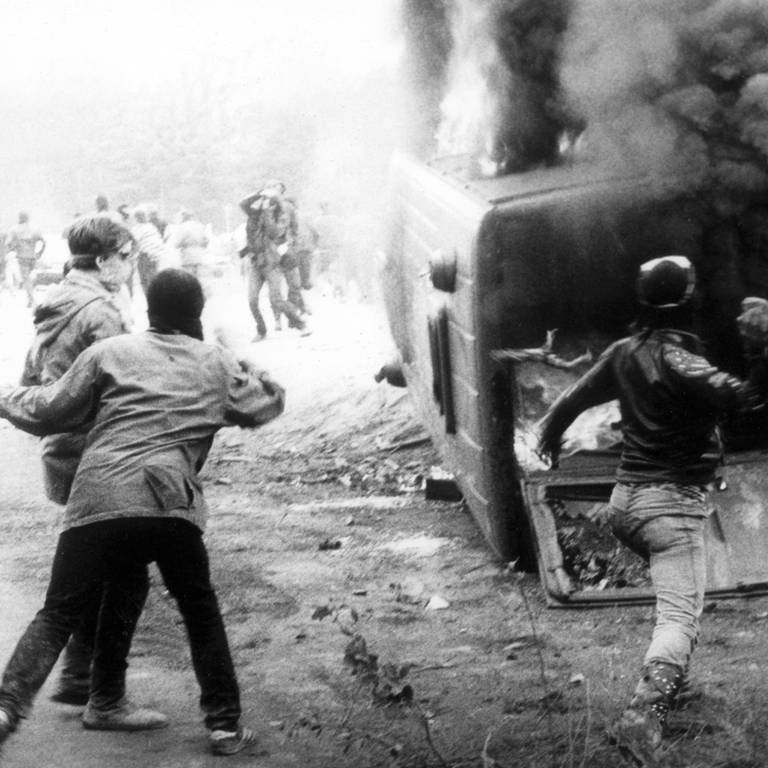 Rund 200 zum Teil vermummte Demonstranten griffen am 20. Mai 1986 in Wackersdorf an einer Zufahrtstraße eine Polizeikontrolle an, warfen diesen Mannschaftswagen um und setzten ihn in Brand.  (Foto: dpa Bildfunk, picture-alliance/ dpa | DB dpa)