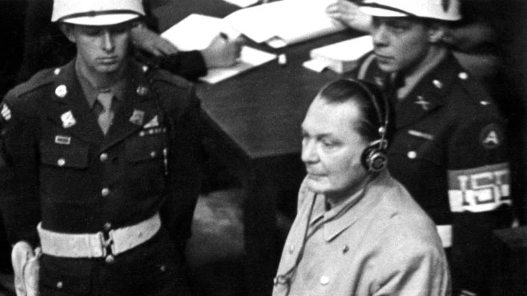 Der ehemalige Reichsmarschall Hermann Göring fragt am 21.11.1945 bei der Eröffnung des 2. Verhandlungstages der Kriegsverbrecher vor dem internationalen Militärgericht in Nürnberg um Erlaubnis, sprechen zu dürfen, nachdem die Frage, ob sich die Angeklagten für schuldig erklären würden von Allen verneint worden war. Göring macht den Richtern stehend deutlich, dass er etwas zu sagen wünsche. Die Bitte wird mit der Begründung verneint, dass Göring später genügend Gelegenheit hätte, zu sprechen.  (Foto: picture-alliance / Reportdienste, picture-alliance/ dpa | dpa DANA)