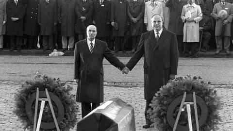 Der französische Staatspräsident Francois Mitterrand (links) und Bundeskanzler Helmut Kohl reichen sich am 22.9.1984 über den Gräbern von Verdun die Hand (Foto: picture-alliance / Reportdienste, (c) dpa - Fotoreport)