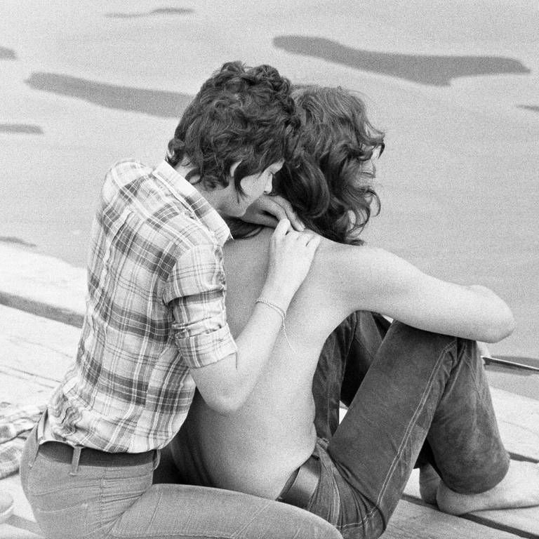 Junges Paar sitz an einem Ufer, Anfang 1970er-Jahre (Foto: picture-alliance / Reportdienste, picture alliance / United Archives | Werner Otto)
