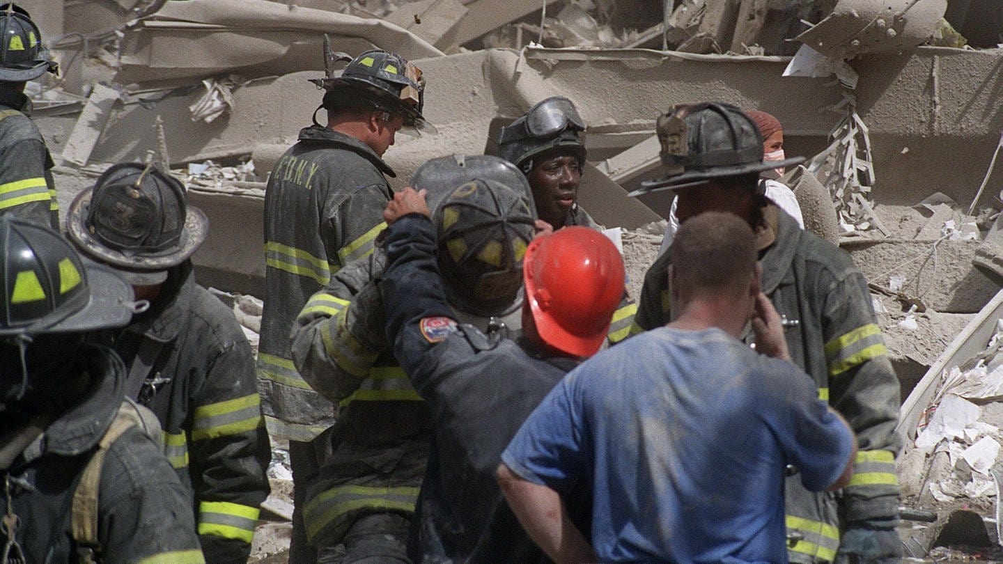 Feuerwehrleute durchsuchen die Trümmer, nachdem Terroristen am Dienstag, den 11. September 2001, zwei Flugzeuge in das World Trade Center in New York steuerten und die Türme zum Einsturz brachten (Foto: picture-alliance / Reportdienste, picture alliance / ASSOCIATED PRESS | BOUDICON ONE)