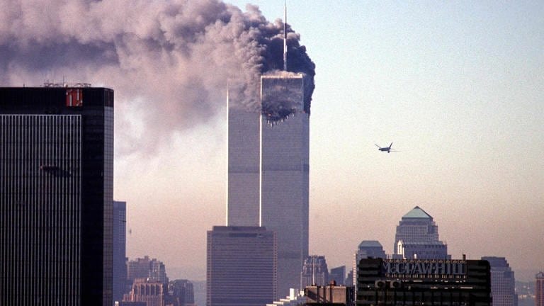 Ein entführtes Verkehrsflugzeug nähert sich dem World Trade Center. Am 11. September 2001 flog es in New York in den Wolkenkratzer, einem Wahrzeichen der Stadt. (Foto: picture-alliance / Reportdienste, picture-alliance / dpa | Seth_Mccallister)