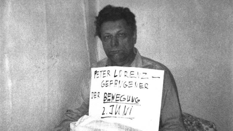 Die Entführer des Berliner CDU-Landesvorsitzenden Peter Lorenz haben sich gemeldet. Dem Berliner Büro der Deutschen Presse-Agentur ging 24 Stunden nach dem Überfall auf den Politiker, der am 27. Februar 1975 entführt wurde, per Post ein Foto zu: Vor dem Entführten ist ein Schild zu sehen mit dem Text: "Gefangener der Bewegung 2. Juni". Am 2. Juni 1967 war in Berlin der Student Benno Ohnesorg während einer Anti-Schah-Demonstration erschossen worden. Aufgenommen am 28. Februar 1975. (Foto: picture-alliance / Reportdienste, Picture Alliance)