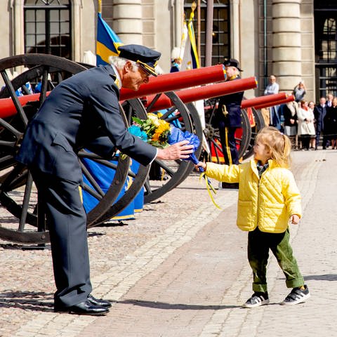 Royals: Schwedens König Carl Gustaf bekommt im Hof des königlichen Schlosses in Stockholm zu seinem Geburtstag Blumen von einem Kind überreicht (Foto: picture-alliance / Reportdienste, Royal Press Europe)