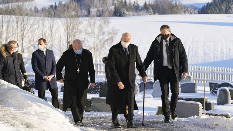 König Harald von Norwegen (2.v.r.) und Kronprinz Haakon (2.v.l) laufen durch den Schnee zu einer Kirche (Foto: dpa Bildfunk, Picture Alliance)
