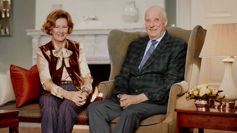 Das Königspaar sitzt in einem schick eingerichteten Zimmer mit Kamin. (Foto: Pressestelle, Jørgen Gomnæs, the Royal Court Norway)
