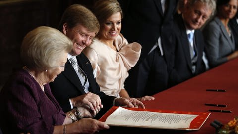 Königin Beatrix reicht ihrem Sohn am Tag seiner Inthronisierung die Abdankungserklärung (Foto: dpa Bildfunk, Picture Alliance)