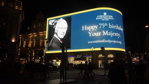 Anlässlich des 75. Geburtstags von König Charles III. wird eine Gratulationsbotschaft auf den Piccadilly Lights, einem großen Werbe-Bildschirm am Piccadilly Circus in London, angezeigt.