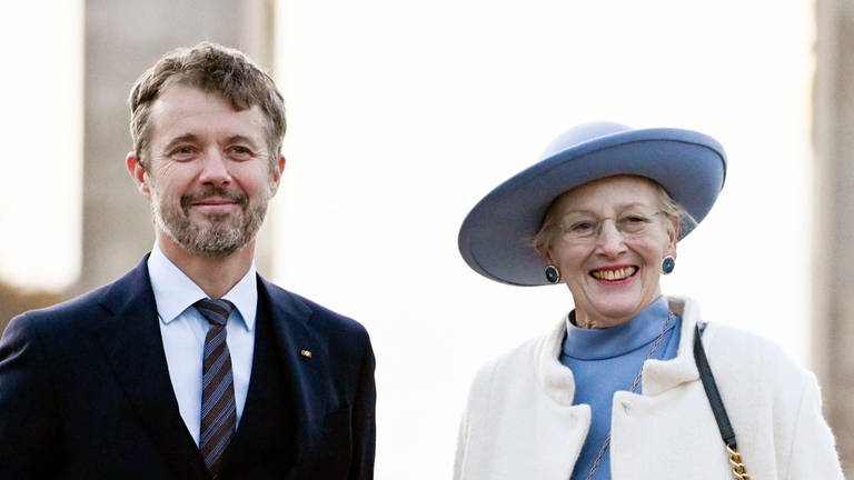 Abdankung: Frederik steht noch als Kronprinz neben seiner Mutter Königin Margrethe II. von Dänemark. Das Foto ist 2021 vor dem Brandenburger Tot in Berlin entstanden. Er trägt einen dunklen Anzug, während die Monarchin ein hellblaues Kostüm trägt mit passendem Hut.