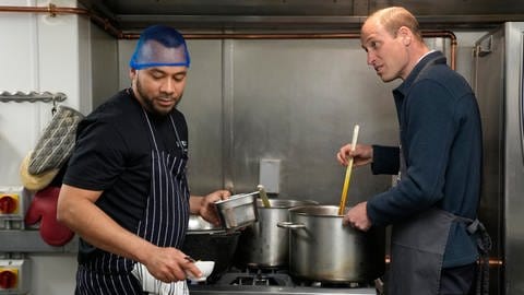 Prinz William hilft dem Chefkoch Mario Confait beim Kochen von  Bolognese während eines Besuchs bei Surplus to Supper in Sunbury-on-Thames. Es ist sein erster Auftritt nach Bekanntwerden der Krebserkrankung seiner Ehefrau Kate. (Foto: dpa Bildfunk, picture alliance/dpa/AP Pool/AP | Alastair Grant)