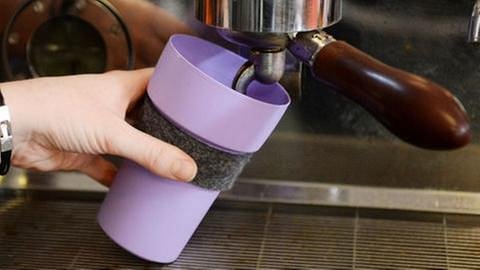 Kaffee wird aus einer Maschine in einen Mehrweg-Kaffeebecher gefüllt (Foto: dpa Bildfunk, Picture Alliance)