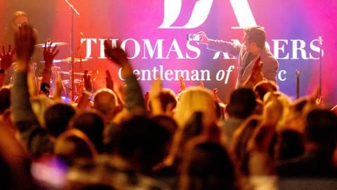Thomas Anders beim Live-Konzert in Koblenz - die besten Bilder: Sänger Thomas Anders steht bei einem Konzert auf der Bühne und macht mit dem Smartphone ein Selfie mit dem Publikum.