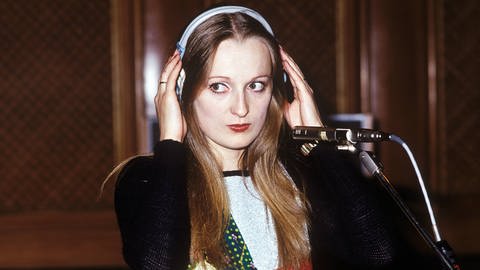 Sängerin Veronika Fischer steht in den 80er Jahren vor einem Mikrofon und hält sich die Kopfhörer. (Foto: IMAGO, Gueffroy)