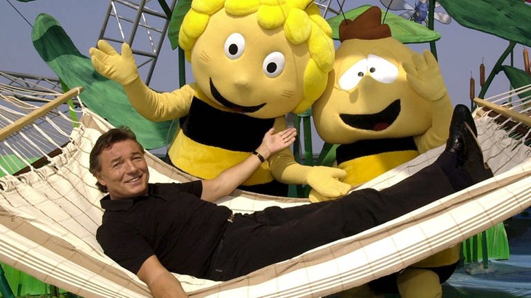 Karel Gott liegt in einer Hängematte neben den überdimensionalen Trickfilmfiguren "Biene Maja" und "Willi" (Foto: dpa Bildfunk, Picture Alliance)