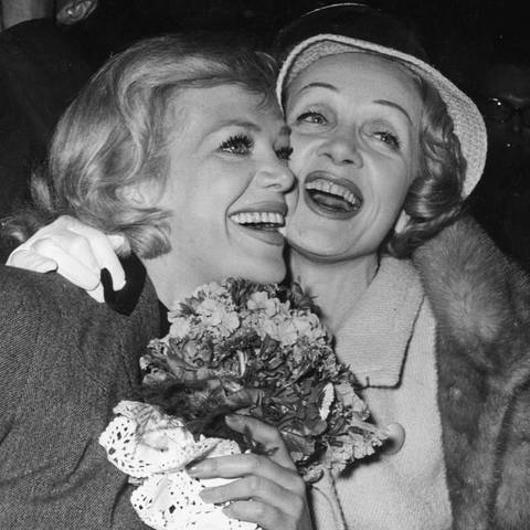 Schwarzweiß-Foto: Die Sängerinnen und Schauspielerinnen Hildegard Knef und Marlene Dietrich umarmen sich und lachen herzlich (Foto: picture-alliance / Reportdienste, akg-images)