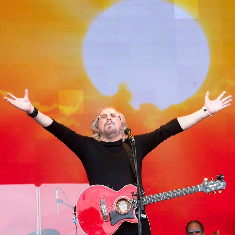 Barry Gibb von den Bee Gees tritt mit Gitarre und erhobenen Armen auf der Bühne auf (Foto: picture-alliance / Reportdienste, picture alliance / SOLO Syndication | Mark Large)