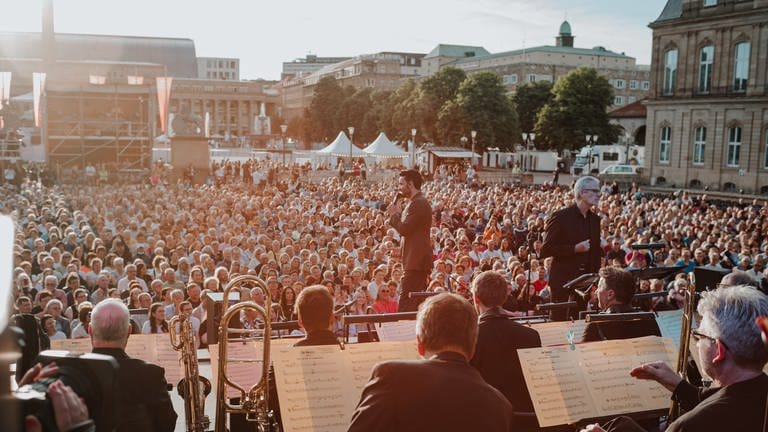 Giovanni Zarrella mit SWR Big Band: Der Schlossplatz mit Publikum im Sonnenlicht, im Vorderdgrund die Bühne mit den Musikern und Giovanni  (Foto: SWR, Ronny Zimmermann)