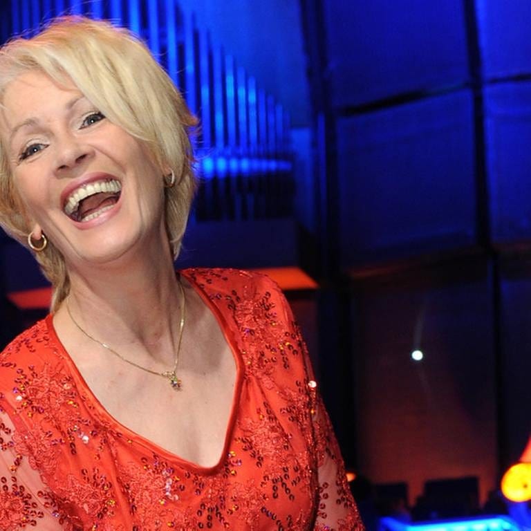 "Komm doch mal rüber" und "Über die Brücke geh'n" sind ihre Hits: Schlagersängerin Ingrid Peters posiert keck im roten Kleid