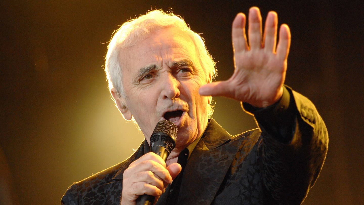 Charles Aznavour musste hart für den Chanson kämpfen: Der französische Chansonnier singt mit erhobenem Arm bei einem Konzert im Jahr 2007. (Foto: dpa Bildfunk, Picture Alliance / Abaca 127562)