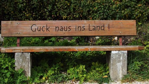 bank mit der Inschrift "Guck naus ins Land" (Foto: IMAGO, imago)