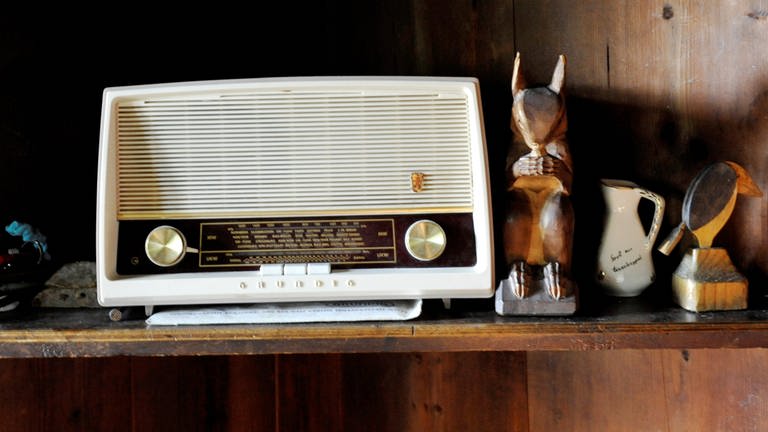 Das Kuba-Radio des Philospohen Martin Heidegger, ein altes Radio, steht auf einem Regalbrett neben Kleinkram wie Holzfiguren und einem Krüglein