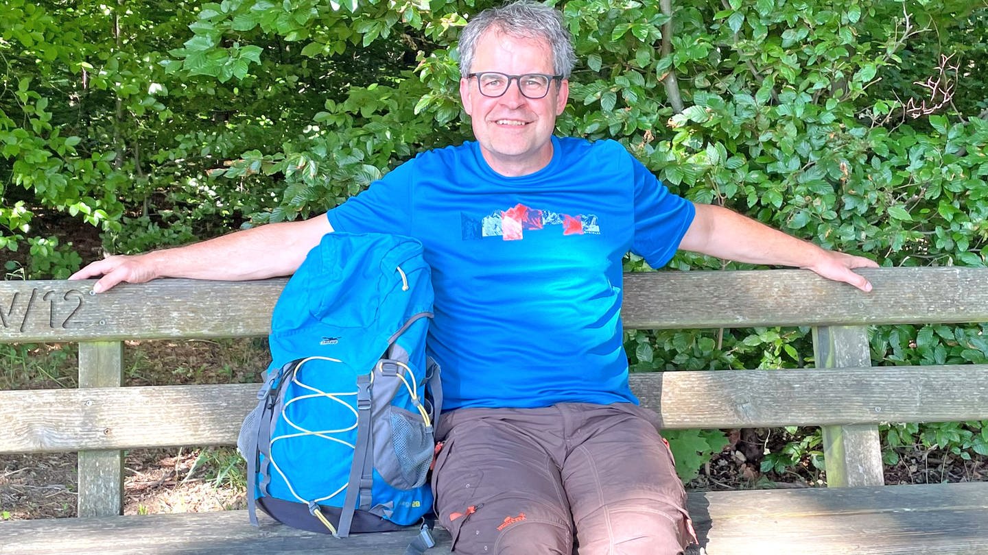 SWR4 Moderator Holger Bentzien sitzt bei einer Rast auf Wanderung, den Rucksack neben sich (Foto: SWR, Holger Bentzien)