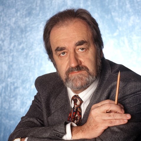 Der Drehbuchautor und Schriftsteller Felix Huby auf einem Archivfoto vom Januar 1997. Er trägt ein graues Jackett und in der rechten Hand hält er einen Bleistift.