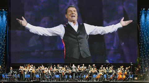 Udo Jürgens auf einer großen Leinwand und davor sein großes Orchester (Foto: Pressestelle, BMC Media)