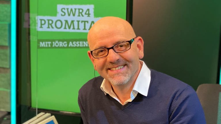 Moderator Jörg Assenheimer lächelnd beim SWR4 Promitalk