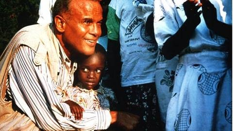 Harry Belafonte mit einem kleinen schwarzen jungen in Ruanda