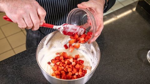 Erdbeer-Sahne-Schnitten backen: Die Erdbeeren werden in die Sahne-Creme untergehoben. (Foto: SWR, Corinna Holzer)