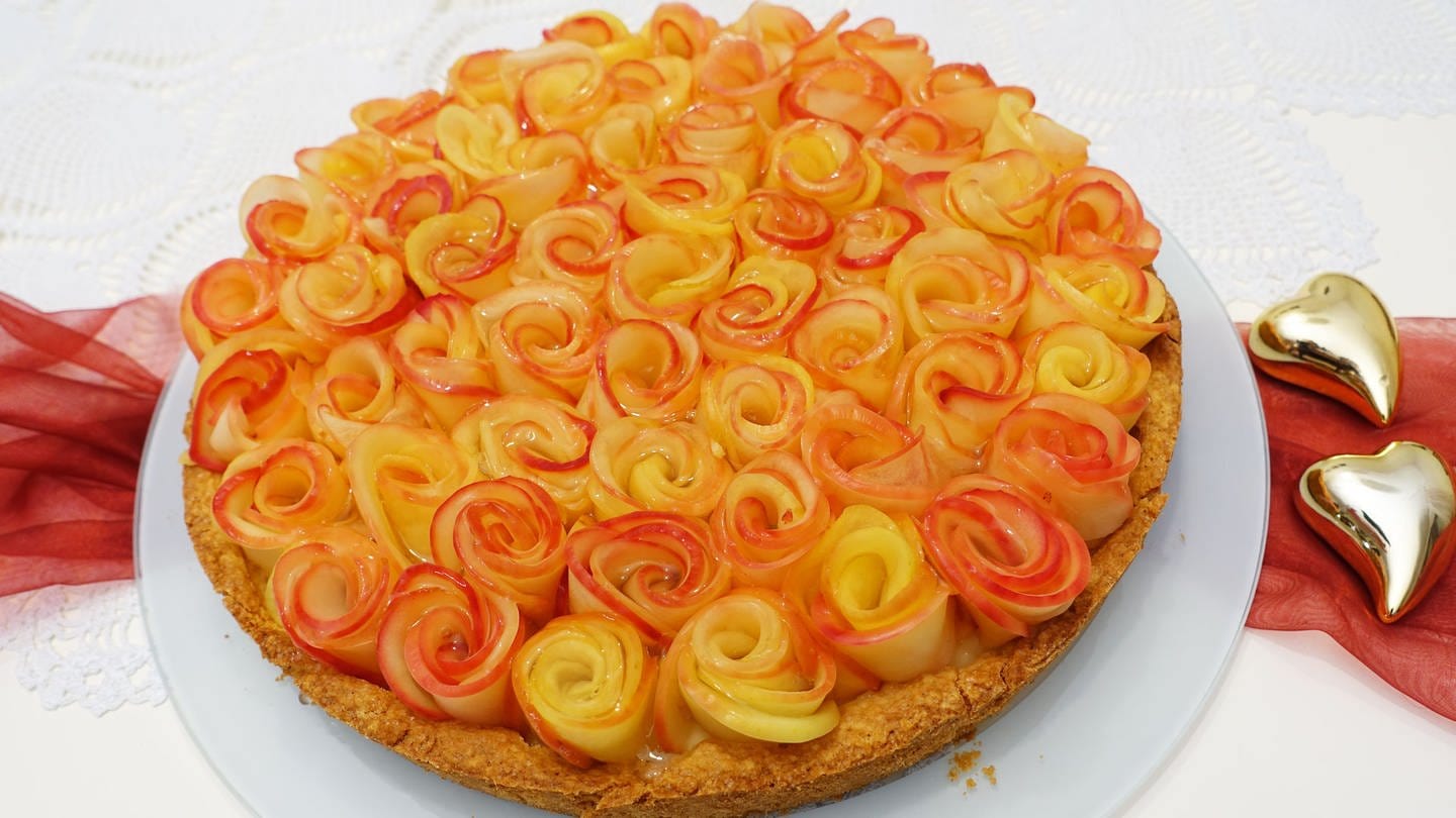runder Kuchen mit Äpfeln, wie Rosenblätter darauf drapiert für Muttertag