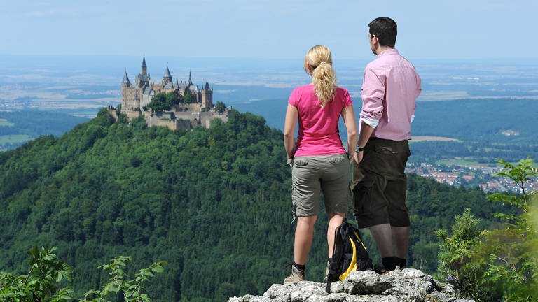 Zwei Wanderer blicken vom Zeller Horn der Schwäbischen Alb auf die Burg Hohenzollern bei Hechingen.  (Foto: dpa Bildfunk, picture alliance / dpa | Volker Bitzer)