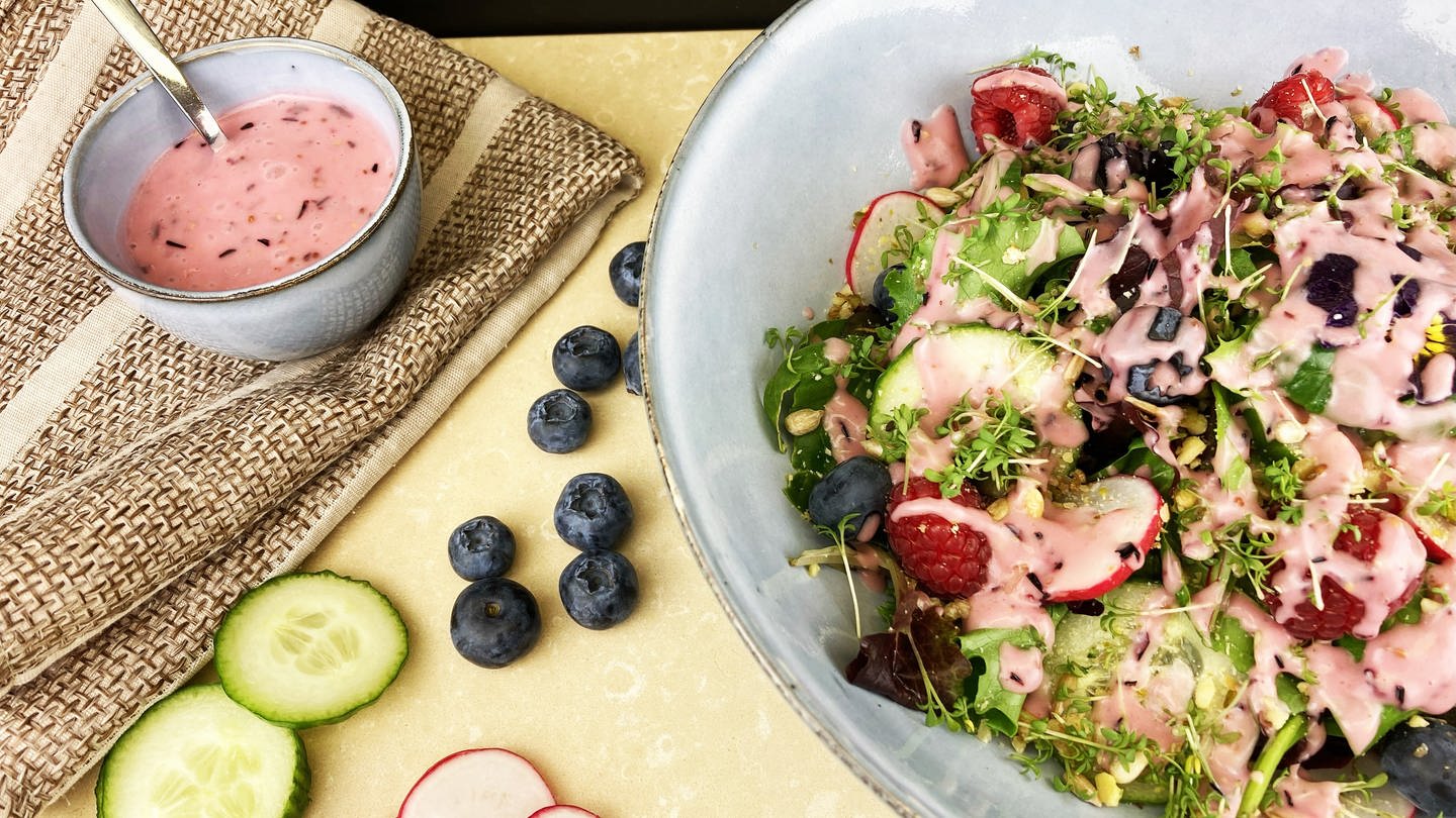 Schüssel mit Salat mit rosa Soße, daneben Blaubeeren, Gurkenscheiben und ein Töpfchen mit rosa Dressing (Foto: SWR, Märte Burmeister)