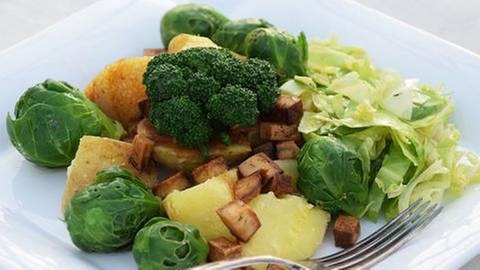 weißer, eckiger teller mit salat aus Kartoffeln, rosenkohl, broccoli und tofu mit einer gabel (Foto: SWR, Veronika Caspers -)
