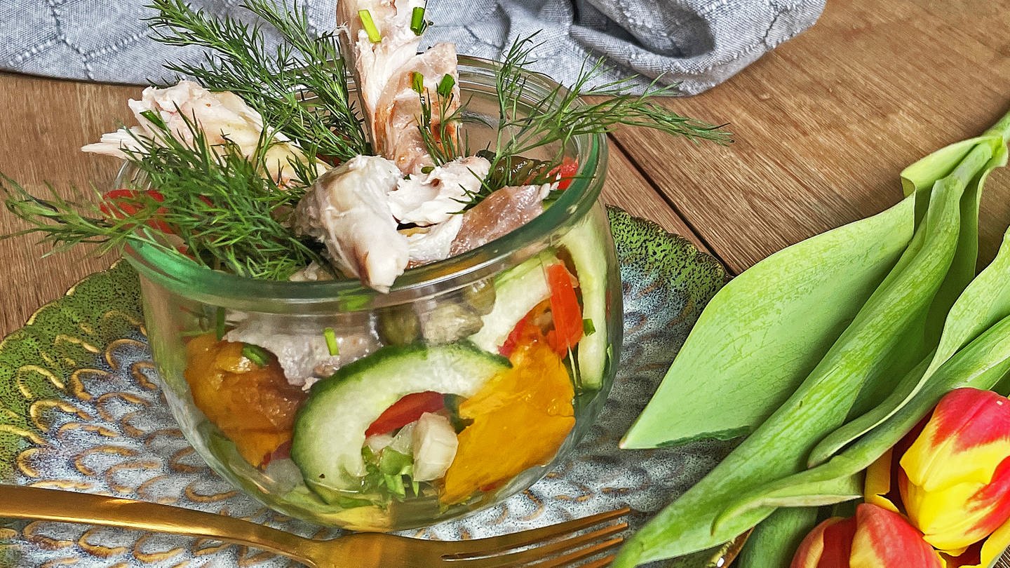 bunter Salat mit Räucherfisch im Glas auf einem grünen Teller mit Gabel, daneben Tulpen (Foto: SWR, Corinna Lutz)