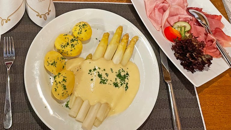 Weißer Spargel mit Sauce Hollandaise und Kartoffeln auf weißem Teller, dazu Schinken auf einer extra Platte (Foto: SWR, Alexandra Daub)