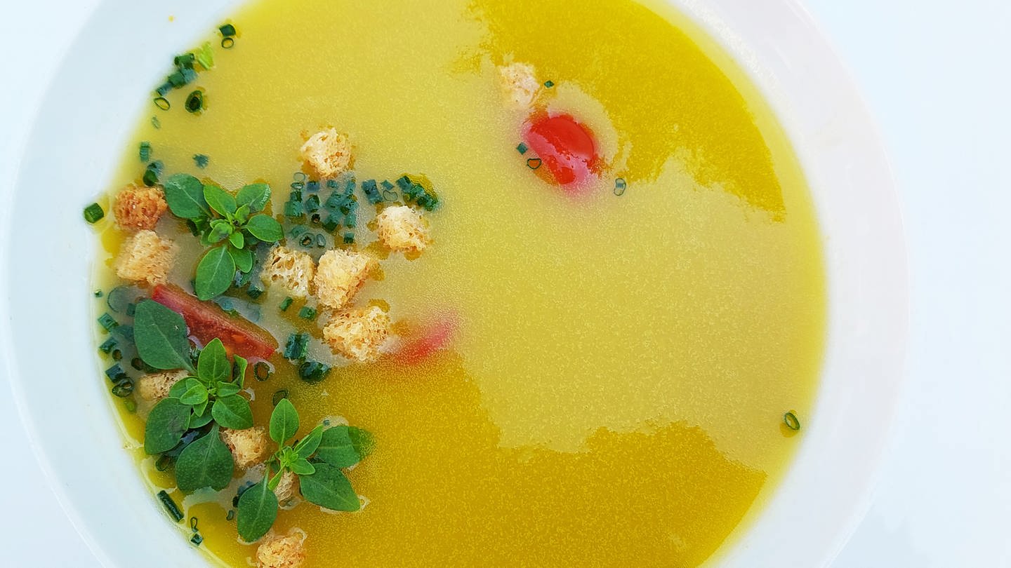 Kalte spanische Suppe: gelbe Gazpacho in einem weißen Teller mit Kräutern und Croutons als Einlage (Foto: SWR, Jens Alinia)