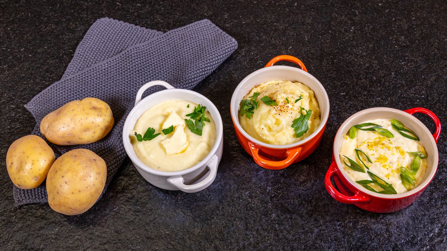 Rezept für Kartoffelpüree: Drei kleine Töpfe in grau, orange, rot stehen im Halbkreis nebeneinander und sind gefüllt mit Variationen von Kartoffelpüree. (Foto: SWR)