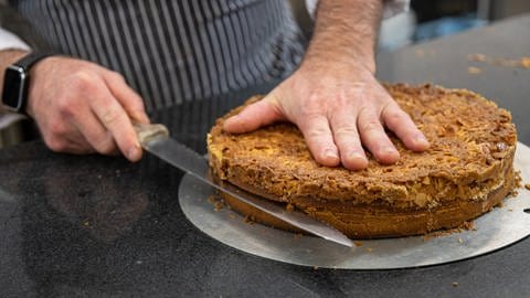 Das Messer zum Halbieren des Hefeteig-Bodens sollte einen Wellenschliff haben und so lang sein, wie der Kuchen breit ist. (Foto: SWR, Corinna Holzer)