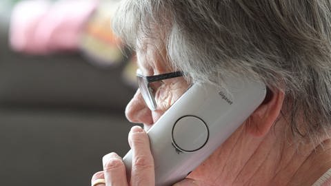 Eine ältere Frau mit grauen kurzen Haaren hält den Telefonhörer ans Ohr (Foto: picture-alliance / Reportdienste, Picture Alliance)