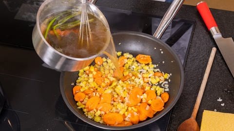 Mairübchen-Hackfleisch-Gratin: Zwiebelwürfel und die Kartoffelwürfel sowie die Hälfte der Karotten anschwitzen und mit der Brühe auffüllen.