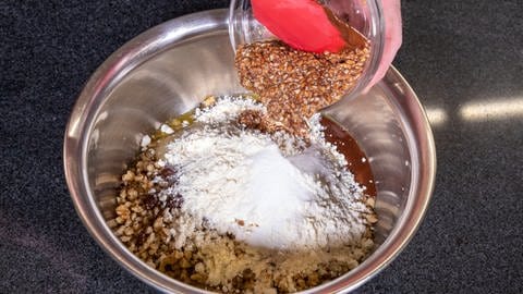 Alle trockenen Zutaten für den veganen Kuchen und die Leinsameneier werden in eine Schüssel geben und gemischt. In dem Rezept kommt auch die Walnuss zum Einsatz.