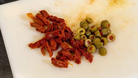 Italienisches Focaccia Rezept: Die Zutaten für die Füllung, wie Oliven und getrocknete Tomaten, und die Dekoration klein schneiden. (Foto: SWR, Corinna Holzer)
