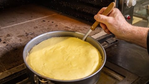 Der Käsekuchen mit Pfirsich wird am Rand mit einem Messer von der Springform gelöst: Damit der Mürbeteig nicht festklebt, löst man den Boden nach rund 15 Minuten von der Form. (Foto: SWR, Corinna Holzer)